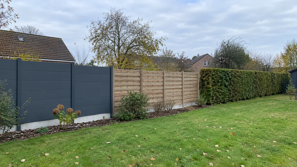 Panneaux rigides, palissade en bois et haie vive côte à côte dans un jardin belge